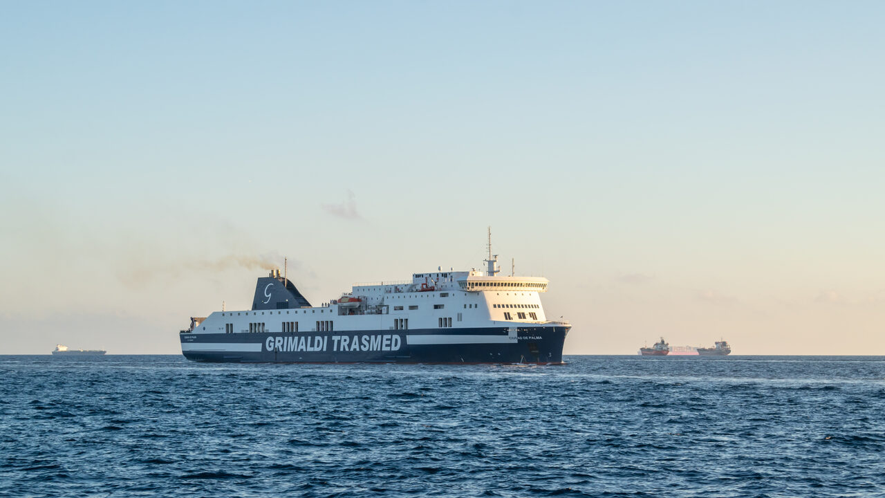 Eine weiß-marineblaue Fähre von Grimaldi Trasmed auf See vor Barcelona in der Abenddämmerung