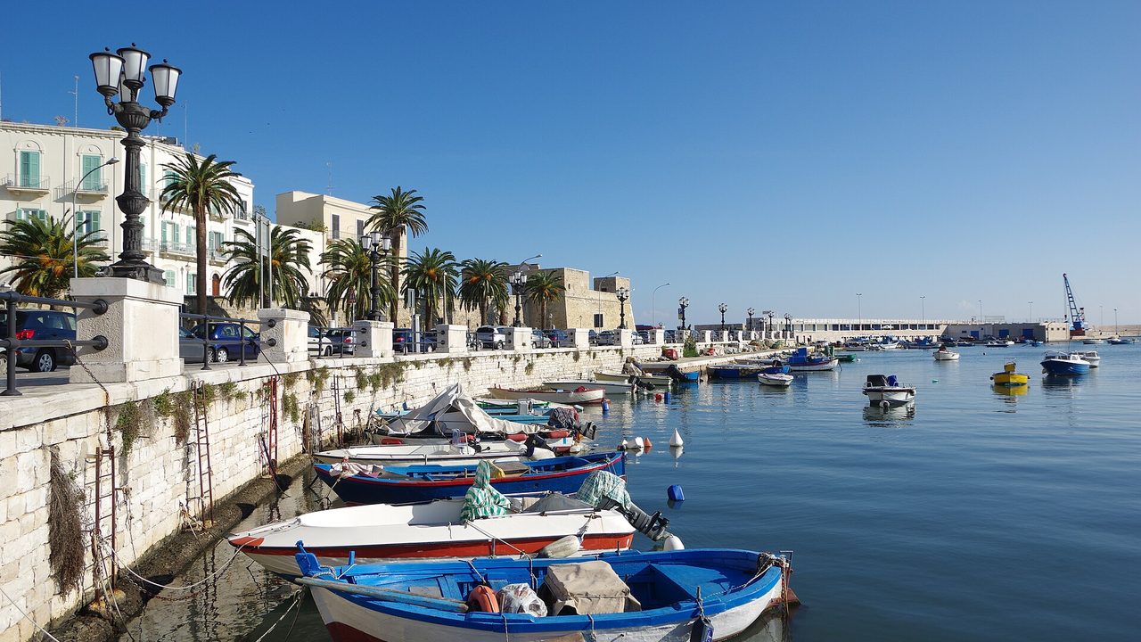 Kleine Fischerboote im alten Hafen von Bari neben der Uferpromenade an einem sonnigen Morgen