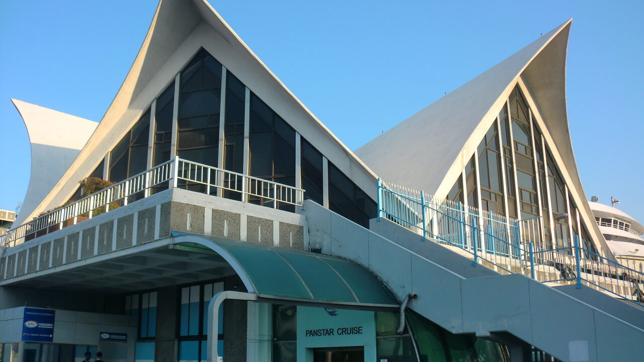 Das geschwungene weiße Dach des Busan International Passenger Terminal mit einem Schild von Panstar Cruise