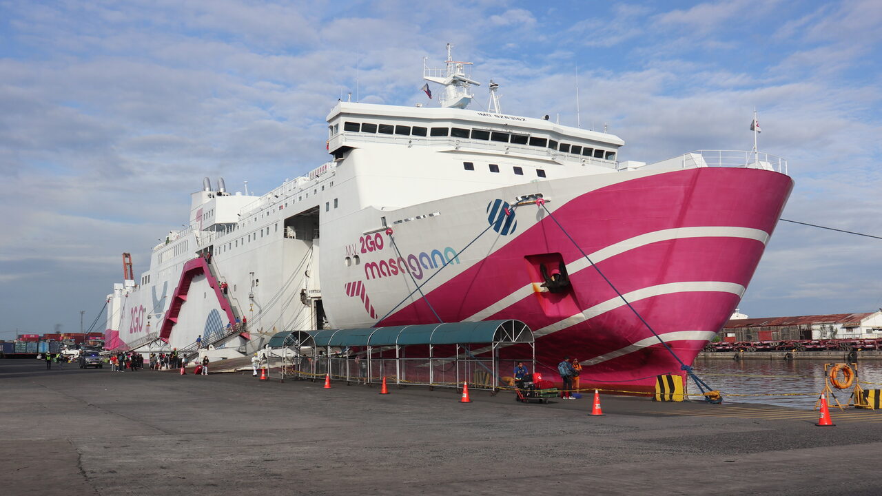 Das rosa-weiße Passagierschiff Masagana von 2GO liegt am Pier 4 im North Harbor in Manila, Fahrgäste gehen an Bord