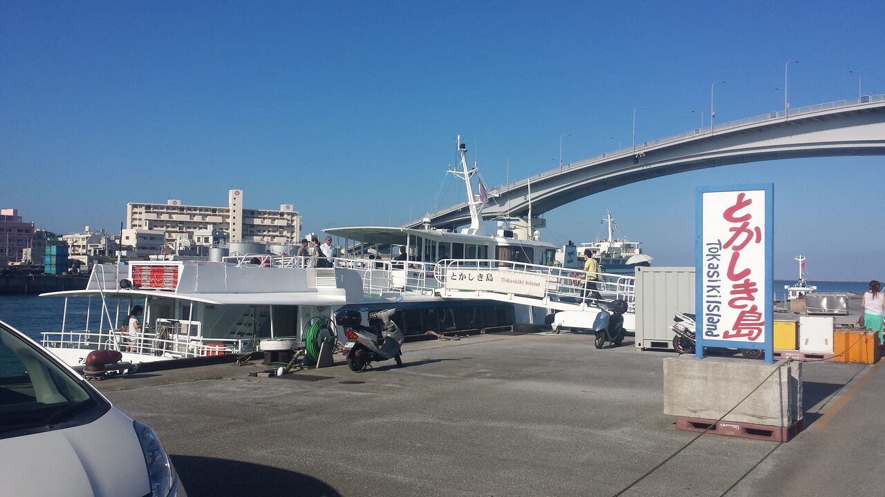 Die Fähre nach Tokashiki liegt am Kai im Hafen von Naha, über ihr eine Straßenbrücke