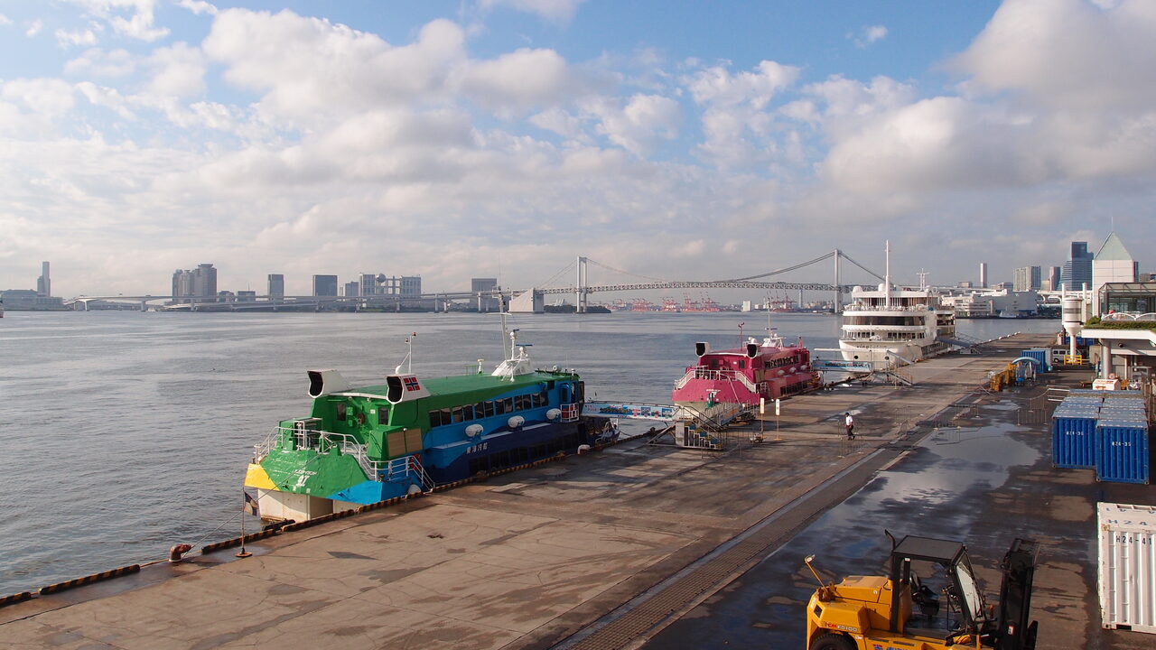 Zwei Hochgeschwindigkeits-Jetfähren von Tokai Kisen liegen am Pier, dahinter die Bucht von Tokio und die Rainbow Bridge
