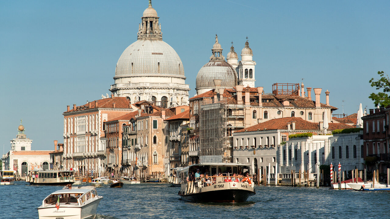 Ein öffentliches Vaporetto und kleinere Boote auf dem Canal Grande vor den Kuppeln von Santa Maria della Salute